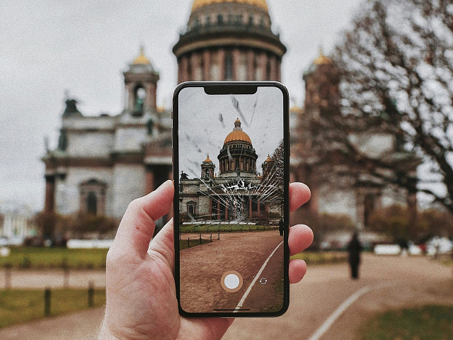 iPhone с разбитым стеклом в руке: трещины поверх работающего экрана